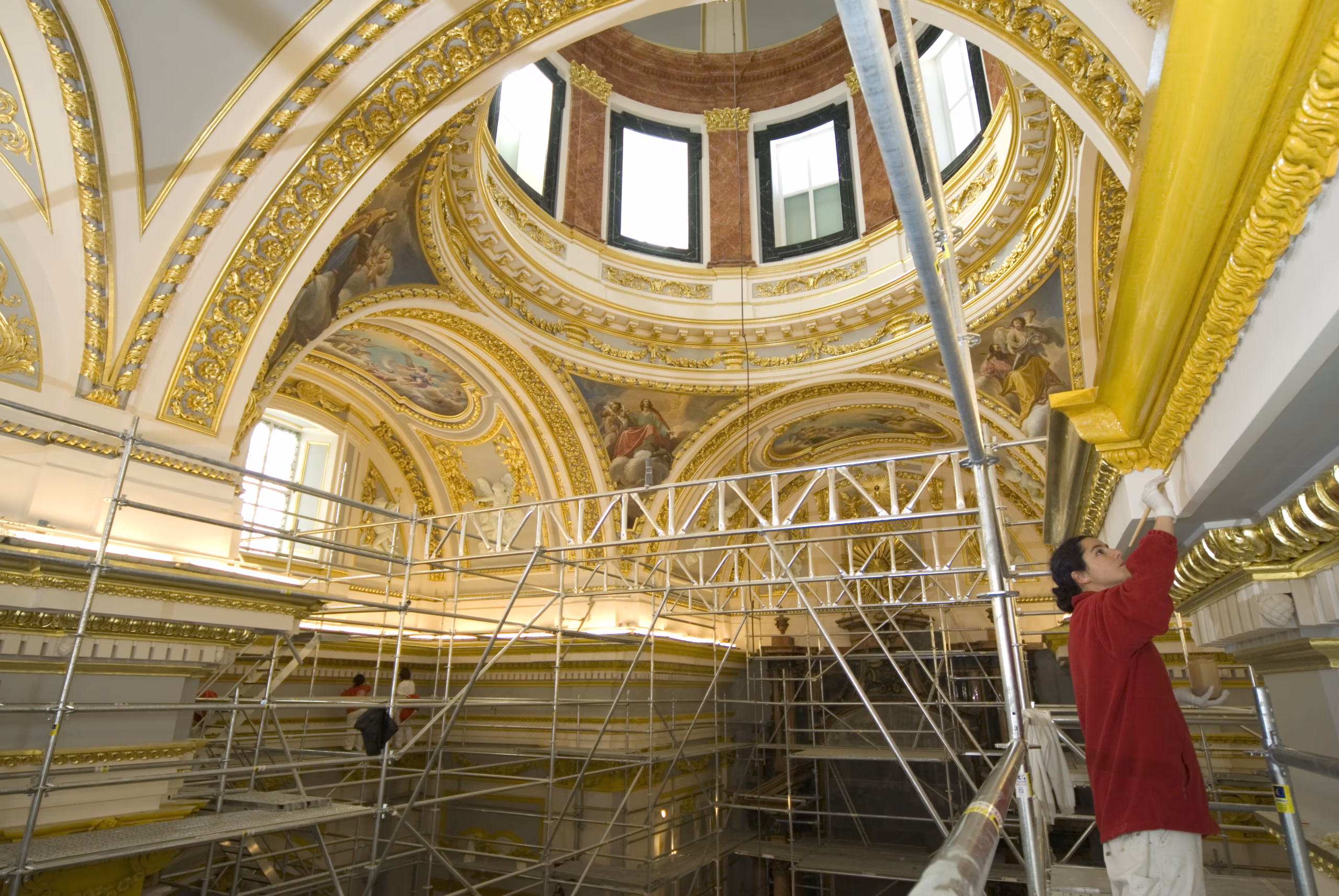 Especialista restaurando un fresco histórico en el interior de una iglesia