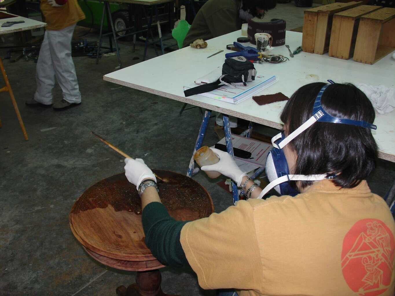 Alumna aplicando técnicas de restauración de muebles en madera durante un curso práctico de formación en oficios artísticos de El Barco