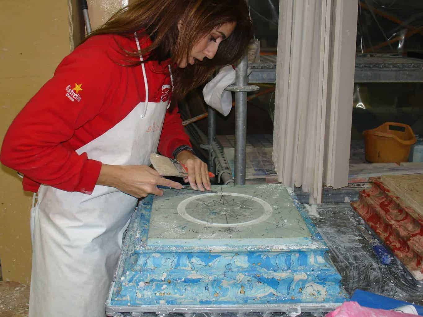 Alumna del taller de formación de El Barco trabajando en técnicas de estuco y marmoleado sobre moldura decorativa