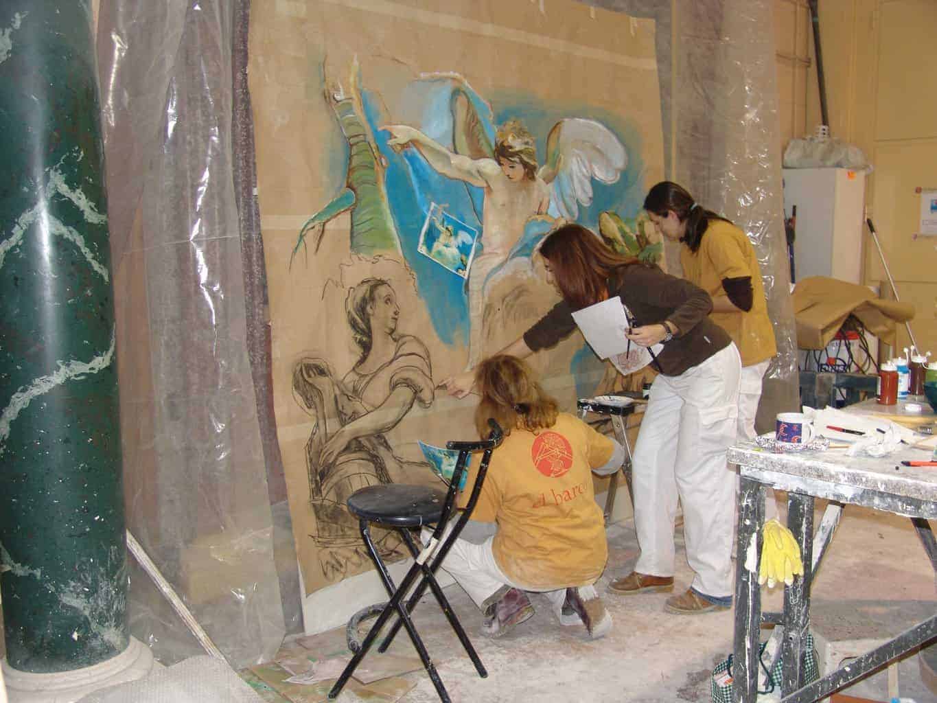 Aplicación de color sobre mural con figuras clásicas durante curso de pintura decorativa